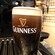 A tall pint of dark beer in a Guinness glass
